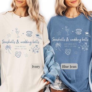 May include: Ivory and blue jean t-shirts with the text "Seashells & wedding bells" and beach-themed illustrations. The ivory shirt says "Future Mrs. Scott" and the blue jean shirt says "Olympia's Bachelorette".