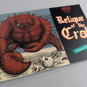 May include: A book cover featuring a large red crab illustration with a green eye, set against a beach scene. The title "Relique of the Crab" is displayed in a stylized font, with the author's name, Adam Dahlheim, below.