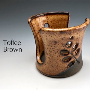 May include: Toffee Brown ceramic dish with a leaf design. The dish has a cutout in the front and is perfect for holding small items.