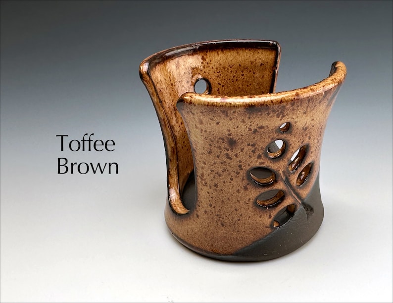 May include: Toffee Brown ceramic dish with a leaf design. The dish has a cutout in the front and is perfect for holding small items.