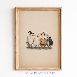 May include: A framed art print featuring a detailed illustration of four ducks dressed in Halloween costumes. One duck wears a witch hat and holds a broom, one is a ghost, one sits inside a carved pumpkin, and one wears a black vampire cape.