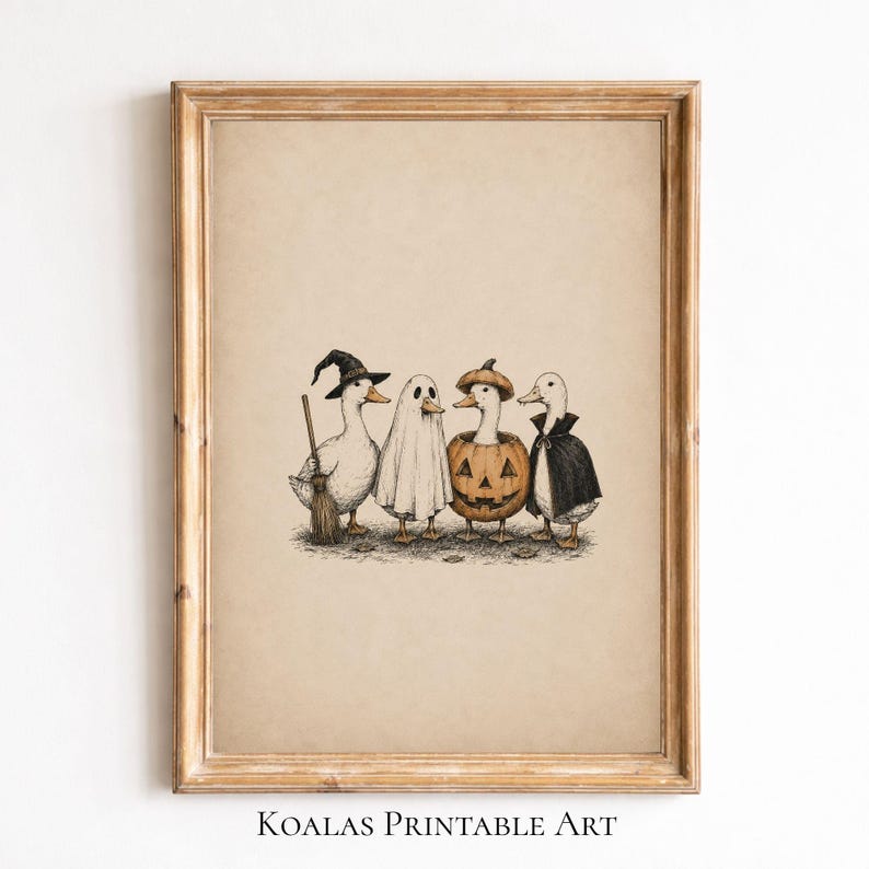 May include: A framed art print featuring a detailed illustration of four ducks dressed in Halloween costumes. One duck wears a witch hat and holds a broom, one is a ghost, one sits inside a carved pumpkin, and one wears a black vampire cape.