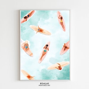 May include: Printable art featuring a watercolor illustration of several people on surfboards in the ocean. The people are wearing swimsuits in various colors. The background is a light blue watercolor wash. The text "KOALAS PRINTABLE ART" is at the bottom.
