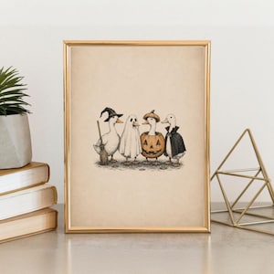 May include: A framed art print featuring a black and white ink illustration of four ducks dressed in Halloween costumes. One duck wears a witch hat and holds a broom, one is a ghost, one is inside a pumpkin, and one wears a black vampire cape.