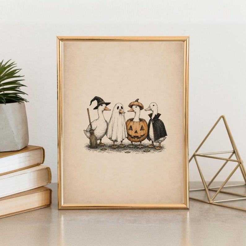 May include: A framed art print featuring a black and white ink illustration of four ducks dressed in Halloween costumes. One duck wears a witch hat and holds a broom, one is a ghost, one is inside a pumpkin, and one wears a black vampire cape.