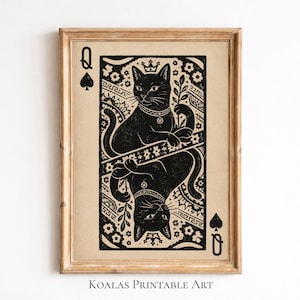 May include: Framed print featuring a black cat design in a playing card style. The artwork depicts a black cat wearing a crown and holding a sprig, with a mirrored image below. The card is the Queen of Spades, with the suit symbol and the letter "Q" in the corners. The text "KOALAS PRINTABLE ART" is at the bottom.