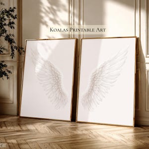 Puede incluir: Dos láminas rectangulares enmarcadas con alas de ángel blancas sobre un fondo blanco liso. El texto KOALAS PRINTABLE ART está centrado sobre los marcos. Cada lámina muestra un ala individual, una orientada a la izquierda y otra a la derecha.