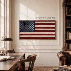 May include: A rectangular wall art print featuring the United States flag with a distressed, textured finish in deep red, white, and navy blue. The text KOALAS PRINTABLE ART is printed in black above the flag. The artwork is displayed on a wall.
