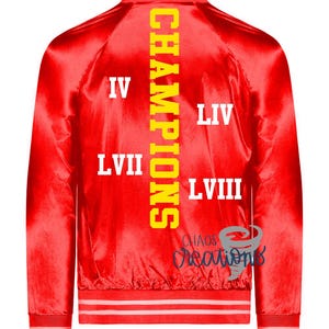 Puede incluir: Chaqueta bomber de sat&eacute;n rojo con texto amarillo en la espalda que dice "CHAMPIONS" y los n&uacute;meros "IV", "LIV", "LVII" y "LVIII".
