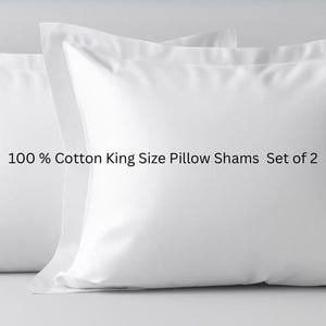 May include: Two white king-size pillow shams made of 100% cotton. The pillowcases are square with a simple, clean design. The text on the image reads "100% Cotton King Size Pillow Shams Set of 2".