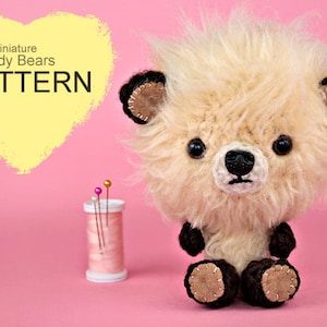 May include: A crocheted teddy bear with brown fur, black eyes, and a black nose. The bear is sitting on a pink surface. The text "Miniature Teddy Bears PATTERN" is in a yellow heart shape in the top left corner of the image.