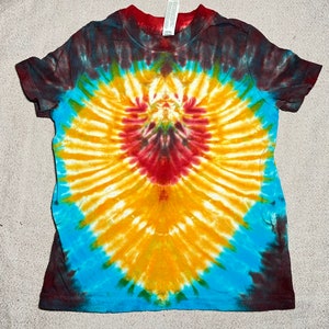 May include: A tie-dye t-shirt with a heart-shaped design in shades of yellow, red, blue, and green.