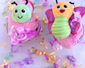 Set of 2 Baby Essentials Cupcakes in a gift box. 2 Bodysuits, Burp Cloth and 2 wrist rattles. Affordable and completely adorable gift.