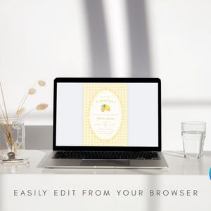 May include: A laptop displays a yellow and white invitation design with a lemon graphic. The laptop is on a white surface, next to a glass of water and a vase with dried flowers. Text at the bottom reads: EASILY EDIT FROM YOUR BROWSER.