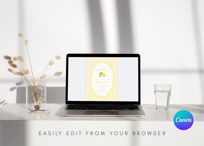 May include: A laptop displays a yellow and white invitation design with a lemon graphic. The laptop is on a white surface, next to a glass of water and a vase with dried flowers. Text at the bottom reads: EASILY EDIT FROM YOUR BROWSER.