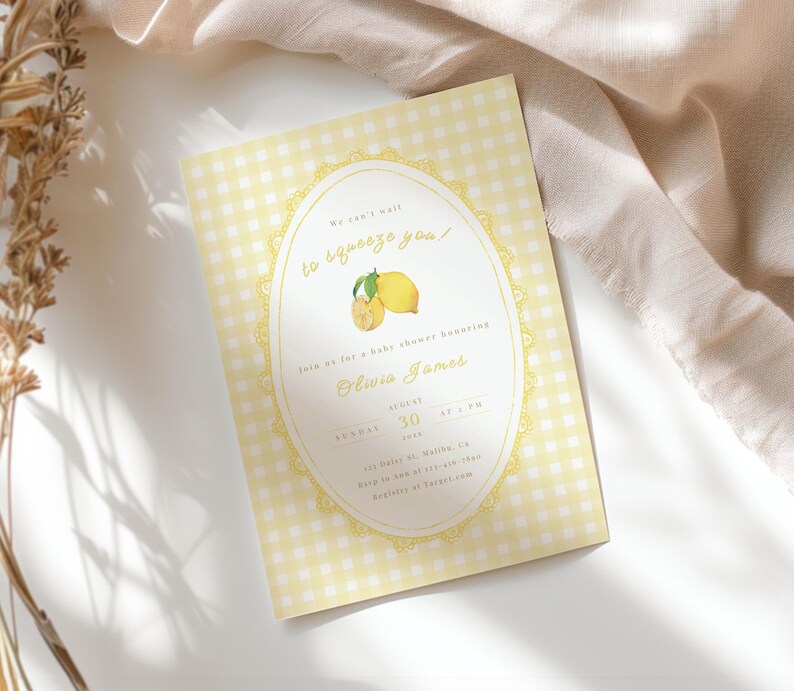 May include: A baby shower invitation with a yellow gingham background. The invitation features an oval design with a lemon illustration and the text "We can't wait to squeeze you!" The invitation is for Olivia James, August 30.