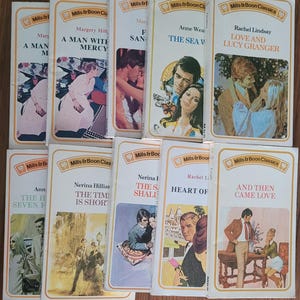 Może przedstawiać: Kolekcja książek vintage Mills & Boon Classics. Okładki przedstawiają ilustracje par i romantycznych scen, z tytułami takimi jak "Love and Lucy Granger" i "The Sea V". Książki mają kremowe tło z białym obramowaniem.