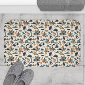 May include: A rectangular bath mat featuring a repeating pattern of surfboards, palm trees, ocean waves, hibiscus flowers, and orange suns on a cream background. The design includes various tropical elements arranged in a dense, colorful motif.