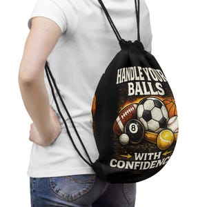 May include: Black drawstring backpack featuring a variety of sports balls, including a football, soccer ball, basketball, baseball, and tennis ball. The text "HANDLE YOUR BALLS WITH CONFIDENCE" is printed on the front.