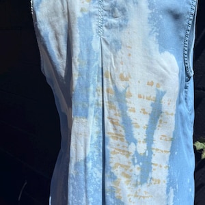 May include: A white ceramic mug with a black handle and the text "But First, Coffee" in a black, bold font. The mug is sitting on a wooden surface. The mug is 4 inches tall.