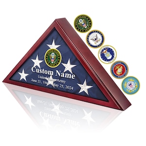 May include: A wooden flag display case with a triangular shape, showcasing a folded American flag. The case has a dark red-brown finish and features the text "Custom Name" and "United States Army". Six military service emblems are displayed.