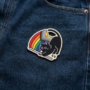 May include: A set of three ceramic canisters with lids, featuring a geometric pattern in shades of blue, white, and gray. The canisters vary in size, with the largest approximately 8 inches tall.