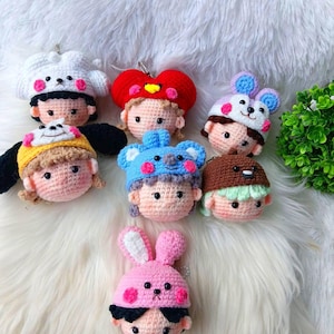 Può includere: Una collezione di portachiavi all'uncinetto fatti a mano con adorabili design di personaggi. Ogni portachiavi mostra un personaggio unico con un cappello distintivo, tra cui un orso, un coniglio e un koala. I portachiavi sono in vari colori, tra cui rosa, blu e bianco.