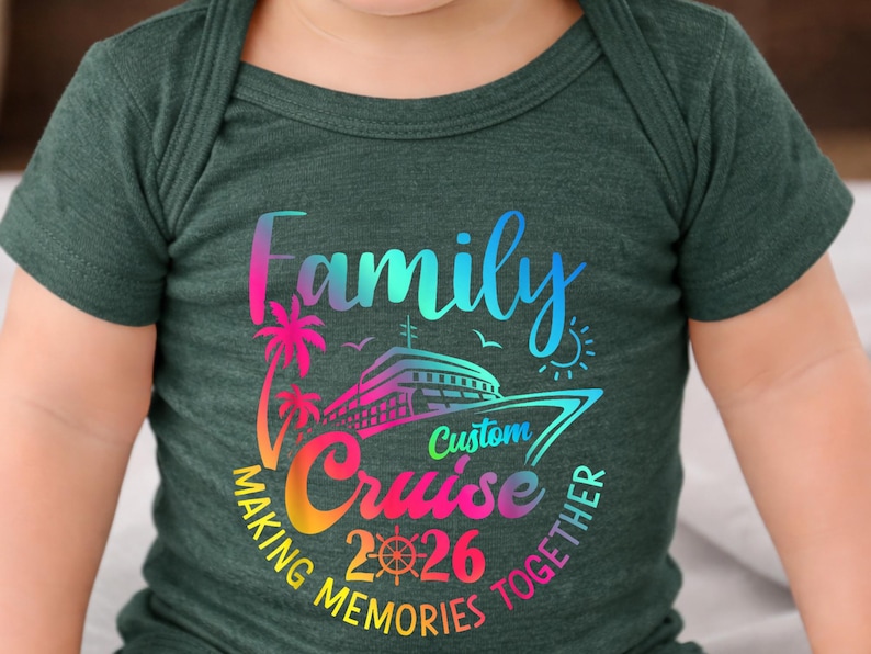 May include: Dark green baby bodysuit with a colourful graphic. The graphic includes the words "Family Cruise 2026" with a cruise ship, palm trees, and the phrase "Making Memories Together."