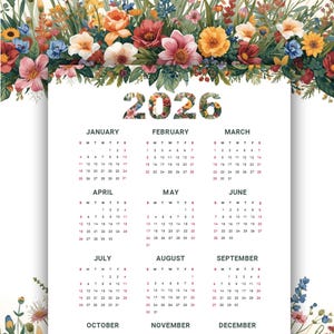 Op de afbeelding: 2026 kalender met bloemaccenten. De kalender heeft een witte achtergrond met maandelijkse lay-outs en data. Kleurrijke bloemen, waaronder rozen en madeliefjes, omlijsten de boven- en onderkant.