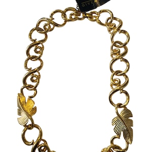 May include: A gold-tone necklace with a chain link design and three gold leaf accents. The necklace has a tag attached that reads "Givenchy".