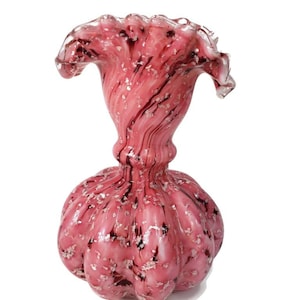 May include: Pink glass vase with a swirled design and a ruffled top.