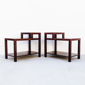 May include: Two matching dark brown wooden side tables. Each table has a rectangular top, a lower shelf, and a unique upper design. The tables are approximately 24 inches long, 18 inches wide, and 24 inches high.