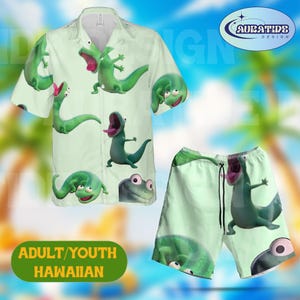 May include: A light green Hawaiian shirt and matching shorts set. The shirt and shorts feature a repeating pattern of cartoon green lizards with open mouths and pink tongues. The set includes the text "ADULT/YOUTH HAWAIIAN".