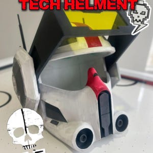 May include: A white and black helmet with red accents and a yellow visor. The helmet has the text "TECH HELMENT" in red. A skull and lightning bolt graphic is on the right side. The helmet has two circular openings on the front.