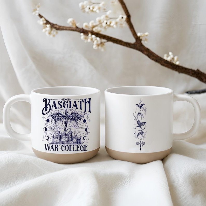 May include: Two white ceramic mugs with a tan base. One mug features the text "BASGIATH WAR COLLEGE" in navy blue, with a castle and celestial design. The other mug has a navy blue dragon design.
