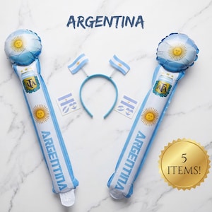 Puede incluir: Un conjunto de cinco art&iacute;culos de fiesta con tem&aacute;tica de Argentina que incluye dos bastones inflables largos con extremos de bal&oacute;n, una diadema azul con dos banderas peque&ntilde;as en resortes y dos pegatinas cuadradas con banderas.