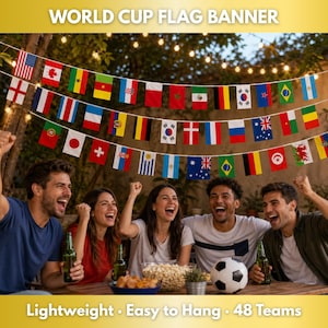 May include: A banner with flags of various countries, strung across a backyard setting. The flags are colorful and represent different nations. The banner is displayed above a group of people celebrating. Text on the banner reads "WORLD CUP FLAG BANNER".