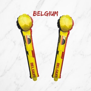 Puede incluir: Dos bastones de animaci&oacute;n inflables con el texto BELGIUM en la parte superior e inferior. Cada bast&oacute;n es amarillo con detalles en negro y rojo, mostrando un gr&aacute;fico de bal&oacute;n de f&uacute;tbol, un mapa de B&eacute;lgica y el texto ROYAL BELGIAN FA 1895.