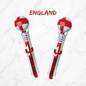 Puede incluir: Dos bastones de animaci&oacute;n inflables con el dise&ntilde;o de la bandera de Inglaterra, una parte superior redonda, el escudo de la selecci&oacute;n nacional de Inglaterra, un mapa de Inglaterra y la palabra ENGLAND impresa en negro. El texto ENGLAND aparece arriba.