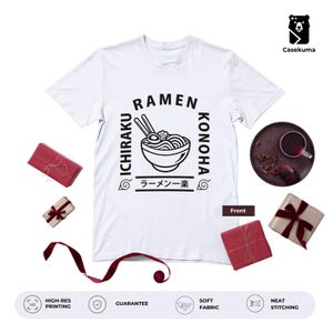 May include: White t-shirt featuring a black graphic of a ramen bowl, chopsticks, and the words "RAMEN ICHIRAKU KONOHA" in a square design. The Japanese characters "ラーメンー楽" are also included. The shirt is surrounded by gift boxes and a ribbon.