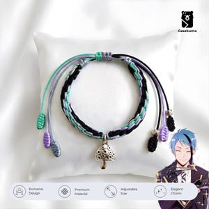 May include: A braided bracelet with black, mint green, and lavender cords. A silver mushroom charm hangs from the center. The bracelet has adjustable cords with decorative ends. The image also includes the text "Exclusive Design", "Premium Material", "Adjustable Size", and "Elegant Charm".