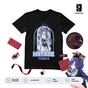 Puede incluir: Camiseta negra con un gráfico de un personaje de anime con cabello morado y el nombre "HAYASE YUUKA". El diseño incluye texto japonés y está impreso en una tela suave. La camiseta tiene cuello redondo y mangas cortas.