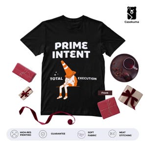 Può includere: Una t-shirt nera a maniche corte con il testo bianco PRIME INTENT e TOTAL EXECUTION. La grafica raffigura una figura seduta con un cono stradale arancione sulla testa. La maglietta è circondata da piccole scatole regalo rosse e beige.