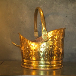 May include: A gold-coloured metal coal scuttle with a hammered finish and a curved handle.