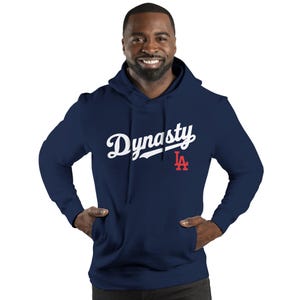 May include: Navy blue hoodie with the word "Dynasty" in white script across the chest. A red "LA" logo is below the word. The hoodie has a hood and a front pocket.