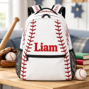 May include: A white backpack featuring a red baseball stitch pattern across the front and sides, with the name Liam embroidered in red lettering. The bag includes black shoulder straps, black zippers, and black mesh side pockets for storage.