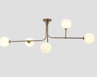 Lampadario in ottone in stile Mid-Century Modern, plafoniera Sputnik a cinque globi, paralumi in vetro lattimo.