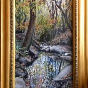 May include: A painting of a forest stream with a rocky bottom and a reflection of the trees in the water. The trees are mostly green with some brown leaves. The stream is flowing from left to right.