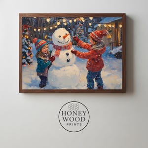 Puede incluir: Una impresión enmarcada representa a dos niños construyendo un muñeco de nieve en una escena invernal nevada. El muñeco de nieve tiene una nariz de zanahoria y una bufanda roja y blanca. Los niños visten gorros, abrigos y guantes de invierno.