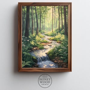 May include: A framed art print depicting a serene forest scene. A stream flows through the lush green landscape, surrounded by tall trees and vibrant foliage. The artwork is encased in a dark wood frame, with the "HONEY WOOD PRINTS" logo at the bottom.